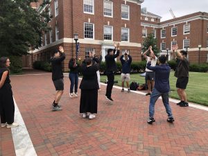 MSIL students on the Homewood Campus jumping and clapping in a circle.